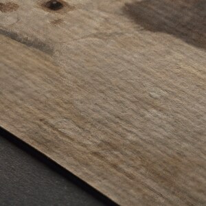 Puede incluir: Primer plano de una superficie de madera marr&oacute;n claro con textura granulada. La superficie tiene un ligero brillo y parece estar hecha de madera natural.