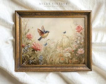 May include: A framed painting of a bluebird flying over a field of pink and white flowers. The painting is in a gold frame and has the text "ATLAS VINTAGE Curated Vintage Art" at the top.