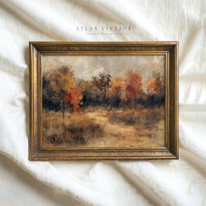 Könnte beinhalten: Ein gerahmtes Gemälde, das eine Waldszene mit Bäumen in verschiedenen Brauntönen, Grün- und Orangetönen zeigt. Das Gemälde ist vor einem hellgrauen Hintergrund platziert und hat einen goldfarbenen Rahmen.