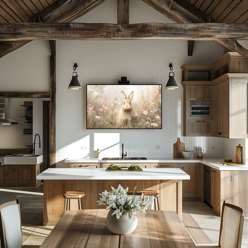 Puede incluir: Una cocina r&uacute;stica con una gran isla y una encimera blanca. La cocina cuenta con un televisor de pantalla plana grande montado en la pared sobre la isla. El televisor muestra una imagen de un conejo blanco en un campo de flores. La cocina tiene armarios de madera y un techo de madera con vigas a la vista.