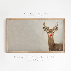 Pode incluir: Uma impressão emoldurada de uma rena com o nariz vermelho sobre um fundo cinza claro. A moldura é de madeira clara. O texto "ATLAS VINTAGE" e "Curated Vintage Art" está na parte superior da imagem. O texto "CURATED FRAME TV ART - 3840x2160 -" está na parte inferior da imagem.
