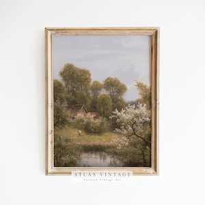 May include: A vintage painting depicting a rural landscape with a small cottage, trees, and a pond. The painting is framed in a light wood frame and has a soft, muted color palette.