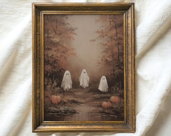 May include: A framed vintage painting featuring a forest scene with three white ghost figures and pumpkins. The artwork has a gold-colored ornate frame. The painting is in autumnal colors, with a river and trees in the background. The text "ATLAS VINTAGE Curated Vintage Art" is at the top.