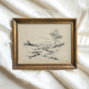 May include: A framed landscape sketch with a gold-colored ornate frame. The artwork features a detailed pen and ink drawing of a natural scene with a tree, a stream, and rolling hills. The text "ATLAS VINTAGE Curated Vintage Art" is at the top.