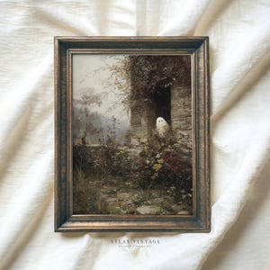 May include: A framed vintage print featuring a spooky scene. The artwork depicts a stone building with a ghost peeking out of a doorway, surrounded by overgrown plants. The frame is a dark, ornate wood. The text "ATLAS VINTAGE" is visible at the bottom.