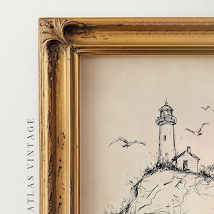 May include: A framed vintage print featuring a black and white sketch of a lighthouse on a rocky cliff, with seagulls in flight. The frame is a distressed gold color, adding to the antique aesthetic. The text "ATLAS VINTAGE" is visible on the left side.
