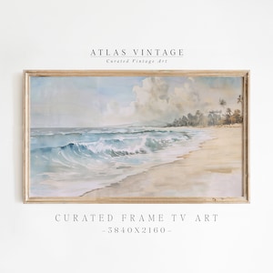 Op de afbeelding: Een ingelijst aquarel schilderij van een strandscène met blauwe golven die breken op de kust. Het schilderij is geplaatst tegen een achtergrond van een bewolkte lucht en palmbomen. De lijst is van licht hout. De tekst "CURATED FRAME TV ART - 3840X2160 -" is onder de lijst gedrukt.