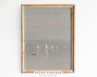 May include: A framed painting of a seascape with sailboats on a calm body of water. The sky is a light blue with a hint of pink. The water is a light gray. The frame is a light wood color. The painting is signed "Atlas Vintage, Curated Vintage Art".