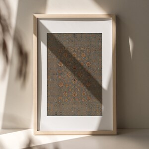 May include: A framed print of a vintage rug with a detailed floral pattern in shades of gold, red, and blue on a gray background.