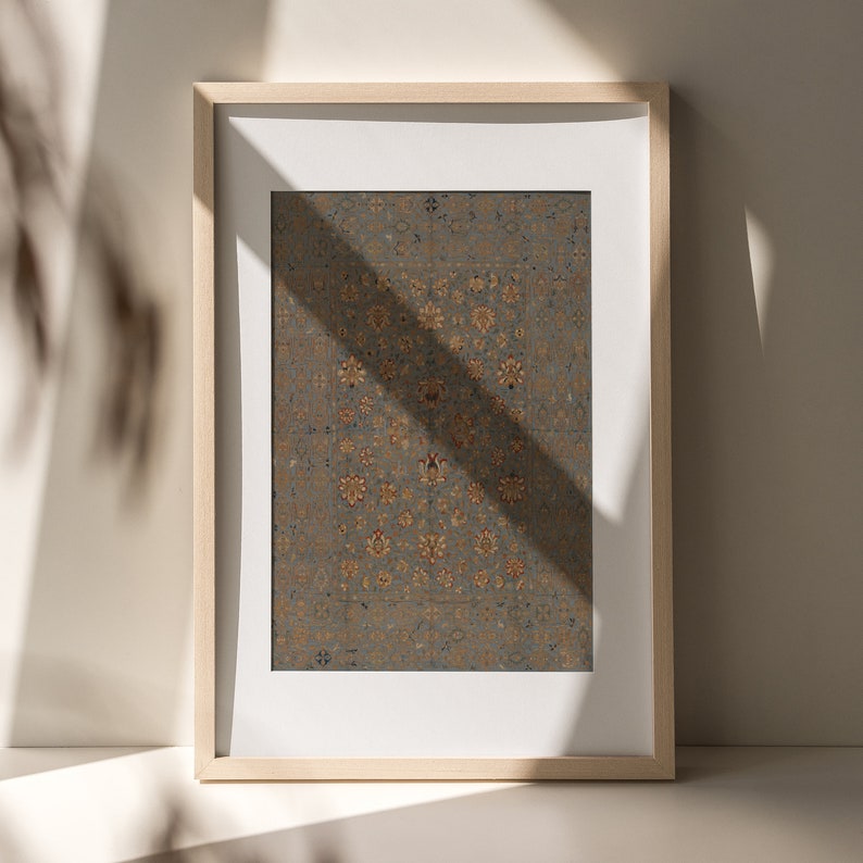 May include: A framed print of a vintage rug with a detailed floral pattern in shades of gold, red, and blue on a gray background.