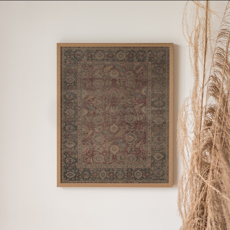 May include: A framed print of a vintage rug with a detailed floral pattern in shades of red, brown, and beige. The rug is surrounded by a dark wood frame.
