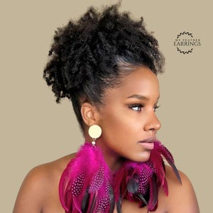 May include: A pair of vibrant fuchsia feather earrings featuring a circular gold stud top and long, layered, spotted dark pink feathers. The text MY FEATHER EARRINGS is visible in the upper right corner. The design is bold, colorful, and textured.