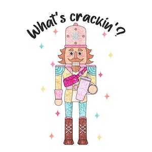 May include: A pink and gold glitter nutcracker holding a pink glitter tumbler with the text "What's crackin'?" above it.
