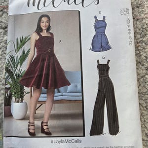 May include: McCall's sewing pattern featuring a burgundy dress, blue romper, and striped jumpsuit designs. The pattern includes the text "#LaylaMcCalls" and size information. Designed and printed in the USA.