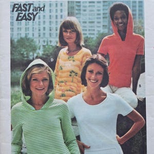 May include: Vintage Butterick sewing pattern for women's clothing. The pattern features a variety of tops, including a striped green hoodie, a white t-shirt, and an orange hooded top. The pattern is size 10.