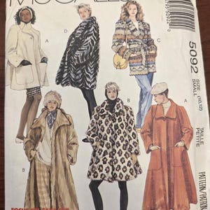 May include: McCall's sewing pattern 5092 featuring coat designs. The pattern includes various styles, such as a white coat, a black and white zebra-striped coat, a multi-colored coat, a leopard print coat, and a rust-colored coat. The size is small (10, 12).