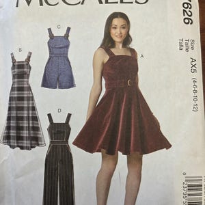 May include: McCall's sewing pattern M7626 featuring four different garment designs. The designs include a plaid dress, a denim romper, a burgundy dress with a belt, and a striped jumpsuit. The pattern size is AX5 (4-6-8-10-12).