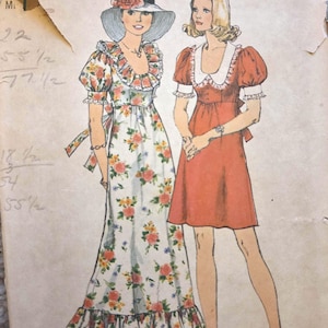 Puede incluir: Patrón de costura Simplicity vintage con dos diseños de vestidos. Uno es un vestido largo con estampado floral con cuello y dobladillo con volantes. El otro es un vestido corto de color sólido con cuello Peter Pan. El patrón está firmado "Becky Knapp".