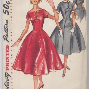 Puede incluir: Patrón de costura Simplicity vintage con ilustraciones de vestidos. La imagen principal muestra un vestido rojo con corpiño ajustado y falda acampanada. Figuras adicionales muestran un vestido gris con cuello blanco. Detalles del patrón impresos.