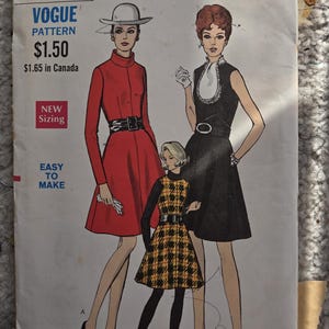 Könnte beinhalten: Vintage Vogue Schnittmuster 7419 mit drei illustrierten Damenmode-Designs. Das Schnittmuster enthält ein rotes Mantelkleid, ein schwarzes Kleid mit weißem Kragen und ein gelb-schwarz kariertes Kleid. Das Schnittmuster ist mit "Easy to Make" gekennzeichnet.