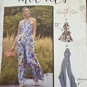 May include: McCall's sewing pattern M8069 featuring a halter-neck jumpsuit with a fabric belt. The pattern includes a color photo of the finished garment in a blue floral print. The pattern is labeled "Learn to Sew".