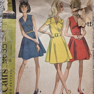 Może przedstawiać: Vintage wzór szycia McCall's 9635 z trzema wzorami sukienek. Ilustracje przedstawiają sukienki w kolorze niebieskim, żółtym i czerwonym, każda z unikalnymi detalami. Wzór zawiera informacje o rozmiarach i jest oznaczony jako "New Sizing".