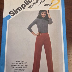 Pode incluir: Padrão de costura Simplicity Beginner's Choice, tamanho 14, com uma mulher em uma blusa cinza de manga comprida e calças cor de ferrugem. O padrão é apenas para malhas elásticas. A cintura é de 71 cm.