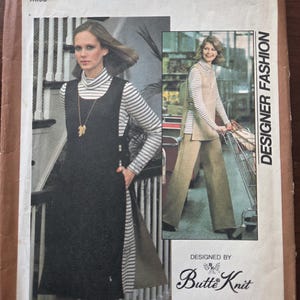 May include: Vintage Simplicity sewing pattern envelope, size 14 Miss. The envelope features two images of a woman wearing a dress and top. The text on the envelope reads "Designer Fashion" and "Butte Knit". The pattern is for stretch knits.