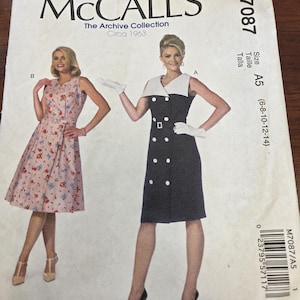May include: McCall's sewing pattern M7087 featuring two vintage dress designs. The pattern includes a sleeveless floral dress and a black dress with white accents and large buttons. The pattern is from The Archive Collection, Circa 1963.