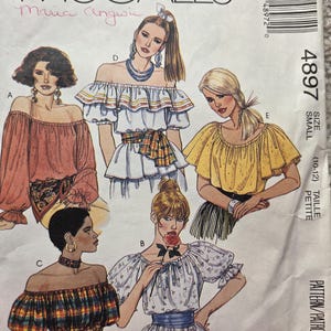 May include: A vintage McCall's sewing pattern showing illustrations of off-the-shoulder tops. The pattern includes designs with ruffled sleeves and different fabric patterns. The pattern number is 4897, size small.