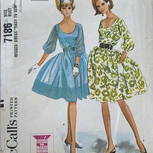 May include: Vintage McCall's sewing pattern for Misses' dresses, size 14, featuring two dress designs. The pattern cover showcases illustrations of the dresses, one in blue and the other in green with a floral print. The pattern is labeled "Easy to Sew."