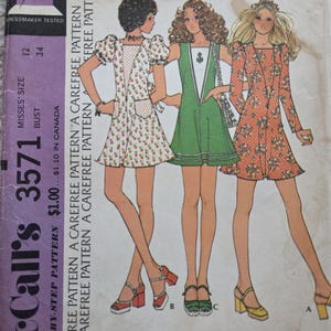 May include: Vintage McCall's 3571 Misses' Dress sewing pattern. The pattern features illustrations of three dresses in various styles. The cover is a faded purple with the McCall's logo and pattern details. The dresses are in shades of red, green, and orange.