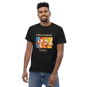 Może przedstawiać: Czarny t-shirt z retro grafiką rolek i tekstem "This is how I roll".