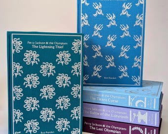 May include: A stack of hardcover books from the "Percy Jackson & the Olympians" series. The top book is teal with a white pattern and the title "The Lightning Thief." The next book is blue with a white trident pattern and the title "The Sea of Monsters."