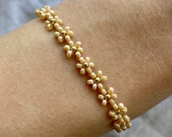 Bracelet fleuri beige avec détails dorés