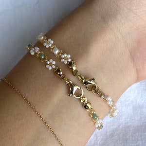 Zartes elegantes Perlenarmband in Pastellfarben mit kleinen goldenen Details en witte Gänseblümchen-Blüten afbeelding 2