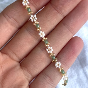 Zartes elegantes Perlenarmband in Pastellfarben mit kleinen goldenen Details en witte Gänseblümchen-Blüten afbeelding 5