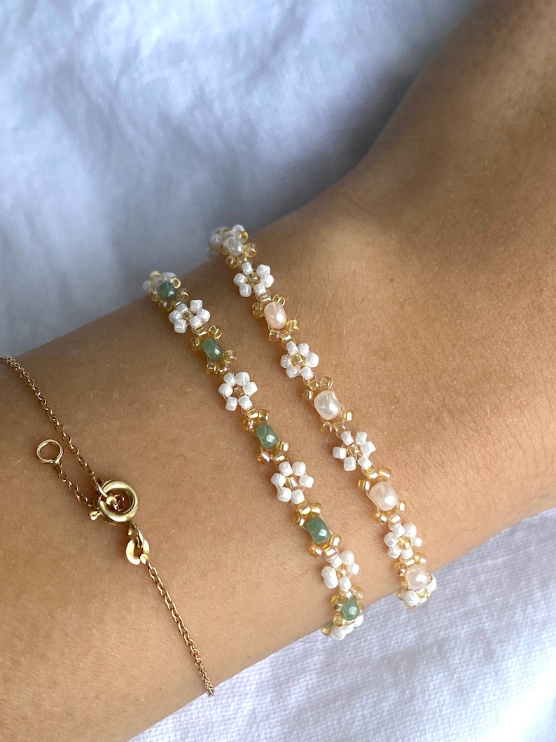 Zartes elegantes Perlenarmband in Pastellfarben mit kleinen goldenen Details en witte Gänseblümchen-Blüten afbeelding 1