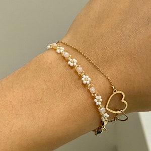 Zartes elegantes Perlenarmband in Pastellfarben mit kleinen goldenen Details en witte Gänseblümchen-Blüten afbeelding 10