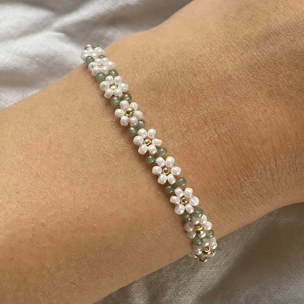 Witte kralenarmband met bloemen en groene bladeren-look