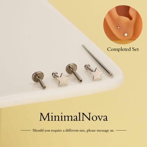 Puede incluir: Un conjunto de pendientes de estrella y tachuelas de color plateado. Los pendientes se muestran sobre una superficie blanca, con una imagen de una oreja que lleva los pendientes. El texto "MinimalNova" es visible.