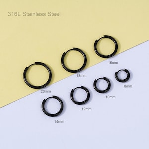 May include: A collection of black stainless steel hoop earrings in various sizes, ranging from 8mm to 20mm. The text "316L Stainless Steel" is displayed at the top. The earrings are arranged on a light yellow and white background.