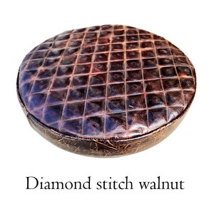 May include: A round brown leather seat cushion with diamond stitching. The cushion has a distressed look and is made of genuine leather.