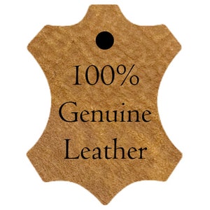 May include: A tan leather tag with a black dot at the top. The text "100% Genuine Leather" is printed in black, indicating the material's authenticity. The tag's shape resembles a piece of leather.