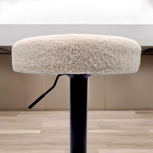 May include: A white faux fur swivel stool with a black metal base and a lever for adjusting the height.