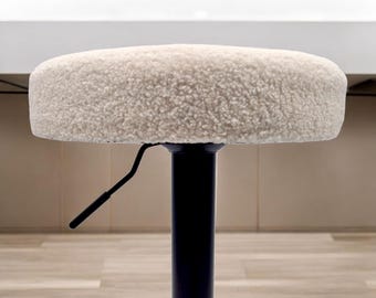 May include: A white faux fur swivel stool with a black metal base and a lever for adjusting the height.