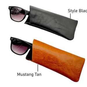 May include: Two leather sunglass cases, one black and one brown. The black case has the text "Style Black" above it. The brown case has the text "Mustang Tan" below it.