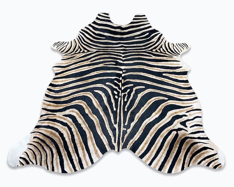 Pode incluir: Um tapete com estampa de zebra com formato &uacute;nico. O tapete apresenta um padr&atilde;o de listras pretas e bege sobre um fundo branco. O tapete foi projetado para se assemelhar a uma pele de zebra e seria um detalhe decorativo para qualquer ambiente.