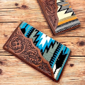 Peut inclure: Deux portefeuilles en cuir marron avec des motifs floraux ciselés. Chaque portefeuille a un panneau en tissu tissé coloré avec des motifs géométriques dans des tons de bleu, blanc, noir et gris.