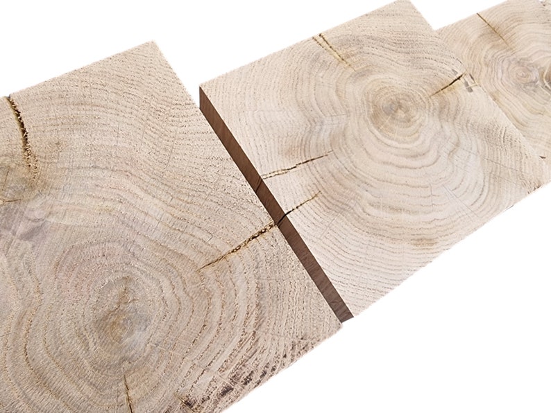 May include: Three pieces of light brown wood with visible grain patterns and knots. The wood is arranged horizontally, with the grain patterns running in different directions.